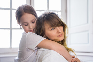 Child girl embracing her lovely mother while enjoying of the time with each other