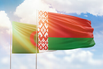 Sunny blue sky and flags of belarus and algeria