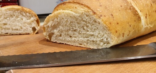 Piece of freshly baked homemade bread cut with a knife close-up