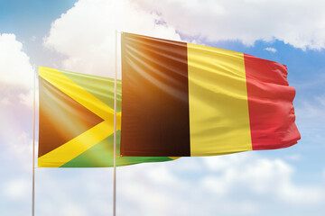 Sunny blue sky and flags of belgium and jamaica
