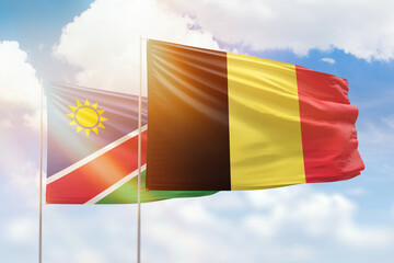 Sunny blue sky and flags of belgium and namibia