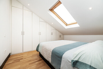 One-bedroom vacation rental apartment with built-in wooden wardrobe and sloping ceilings with large skylights