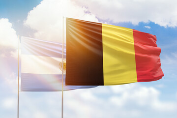 Sunny blue sky and flags of belgium and argentina