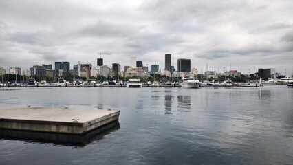 Naklejka premium Yacht Club marina harbor ramp sea water bay vessel sailboat boat motorboat pier bench balcony restaurant bar parking cement path stone texture Rio de Janeiro