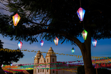 decoração junina de rua com bandeirinhas coloridas e balões decorativos iluminados