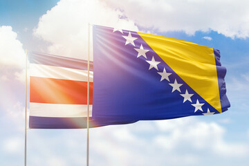 Sunny blue sky and flags of bosnia and costa rica