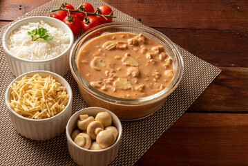 Chicken stroganoff accompanied with rice, salad and potato straw.