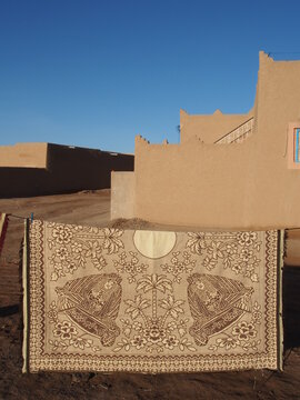 Des tapis sèchent devant une maison du sud marocain