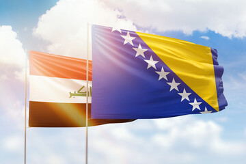 Sunny blue sky and flags of bosnia and iraq