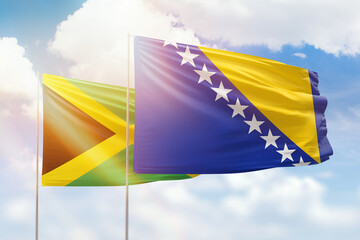 Sunny blue sky and flags of bosnia and jamaica