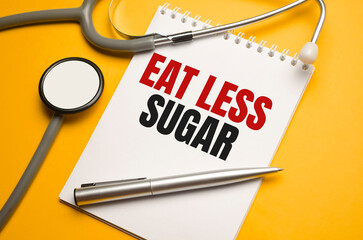 eat less sugar words on notebook and stethoscope on orange background