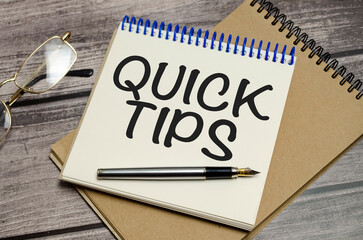QUICK TIPS words on notebook on wooden background