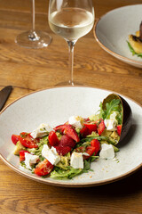Tasty and healthy salad with arugula, brie cheese, avocado, cherry tomatoes and strawberry. Top view. The flat lay. Banner