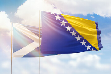 Sunny blue sky and flags of bosnia and scotland