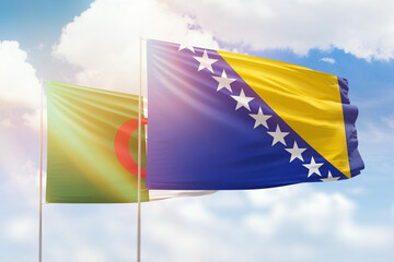 Sunny blue sky and flags of bosnia and algeria