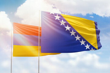 Sunny blue sky and flags of bosnia and armenia