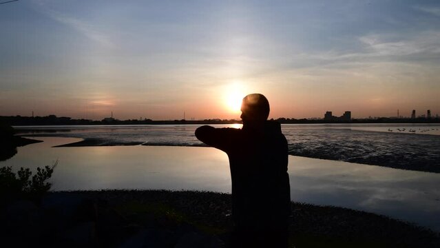 sunrise shadowbox workout during morning rising sun, man in silhouette working out.