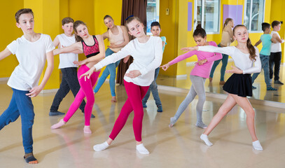 Group of children participating in dance class, following their teacher in the dance school