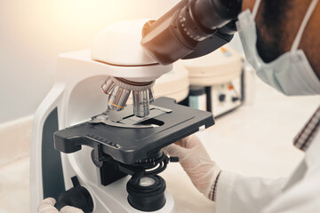 Latin scientist doing an analysis in a microscope in a hospital