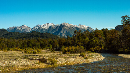 River in a beautiful meadow with snowy mountains in the background. Los Alerces National Park