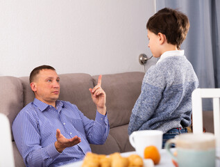 Worried father moralizing preteen son at home. Parenting concept..