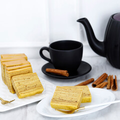 Slice Lapis Legit on Plate and Whole Cake Full Square Plain Indonesian Layer Cake or Lapis Legit