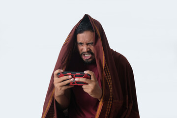 angry man wrapped in blanket while playing phone