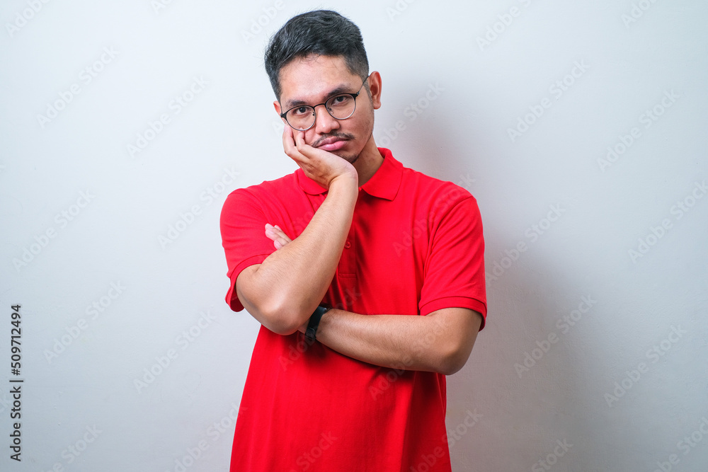 Wall mural young asian man wearing red shirt and glasses thinking looking tired and bored with depression probl