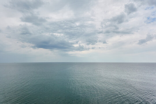 Baltic sea under dramatic clouds. Thunderstorm. Blue sky. Panoramic aerial view from the coast. Seascape. Cyclone, gale, storm, rough weather, meteorology, climate change, natural phenomenon