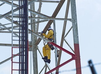 Fototapeta premium A maintenance worker on a communication tower
