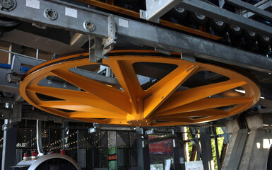 Large yellow metal wheel for turning the cable of the ski lift