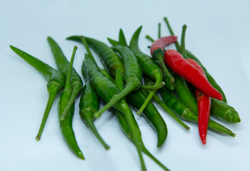 Organically grown green and red peppers are sold in the organic vegetable market with a spicy flavor for Asian food ingredients on a light green background.