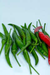 Organically grown green and red peppers for sale in the organic vegetable market with a spicy taste for Asian food ingredients on a blue background.