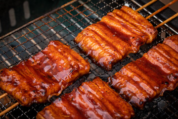 網で焼かれる鰻　eel	