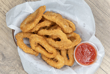 Overhead view of delicious basket of fried calamari rings for an appetizer of a seafood meal