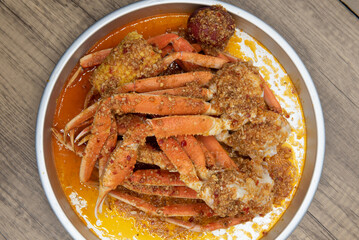 Overhead view of delicious buttery seasoned snow crab legs with corn on the cob for a great seafood...