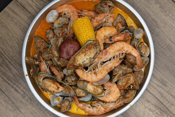 Overhead view of delicious boiled seafood meal of shrimp, corn on the cobb, sausage, clams, and potatoes for tasty seafood meal