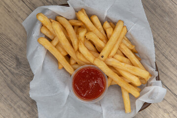 Overhead view of delicious basket of french fries with ketchup for a perfect appetizer to a deep fried meal