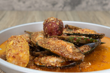 Delicious buttery and seasoned plate of green mussels in the shell with corn and potato for a great seafood meal