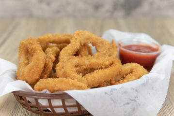 Delicious basket of fried calamari rings for an appetizer of a seafood meal