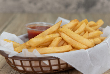 Delicious basket of french fries with ketchup for a perfect appetizer to a deep fried meal