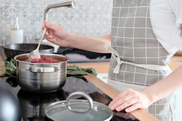 Woman cooking soup in the kitchen