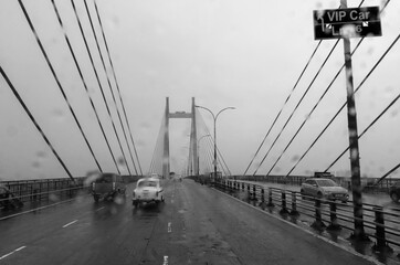 Kolkata, West Bengal, India - 17th August 2019 : Vidyasagar Setu over river Ganges, known as 2nd Hooghly Bridge. Abstract black and white image shot aginst glass with raindrops all over it, monsoon.
