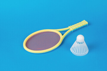Yellow rackets and a white badminton shuttlecock on a blue background.