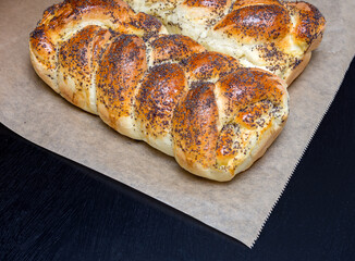 Freshly baked buns sprinkled with poppy seeds on a dark table background. Baking. Cooking concept.