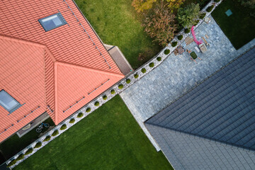 Closeup of attic windows on house roof top covered with ceramic shingles. Tiled covering of building