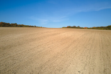 Fototapeta na wymiar Plowed agricultural field with cultivated fertile soil prepared for planting crops in spring