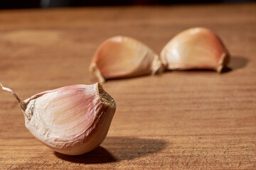 Fresh garlic clove, used as seasoning or spice, placed on a wooden base