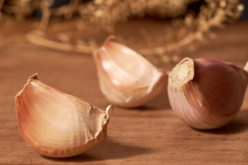Fresh garlic clove, used as seasoning or spice, placed on a wooden base