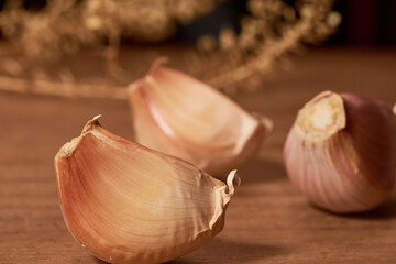 Fresh garlic clove, used as seasoning or spice, placed on a wooden base